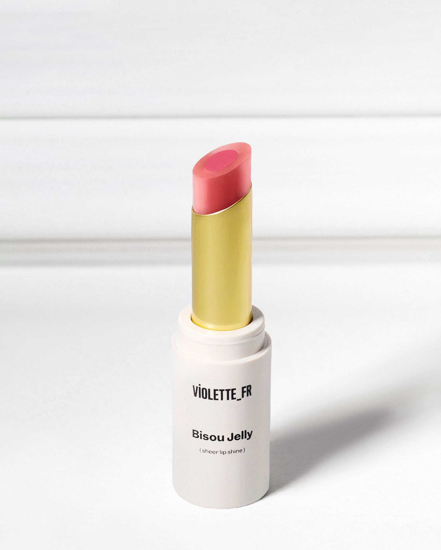 Bisou Jelly - Aïssa - Violette_FR Bisou Jelly (sheer lip shine) in a two-toned pink shade, with a gold inner tube, standing upright. - Image 34 of 34
