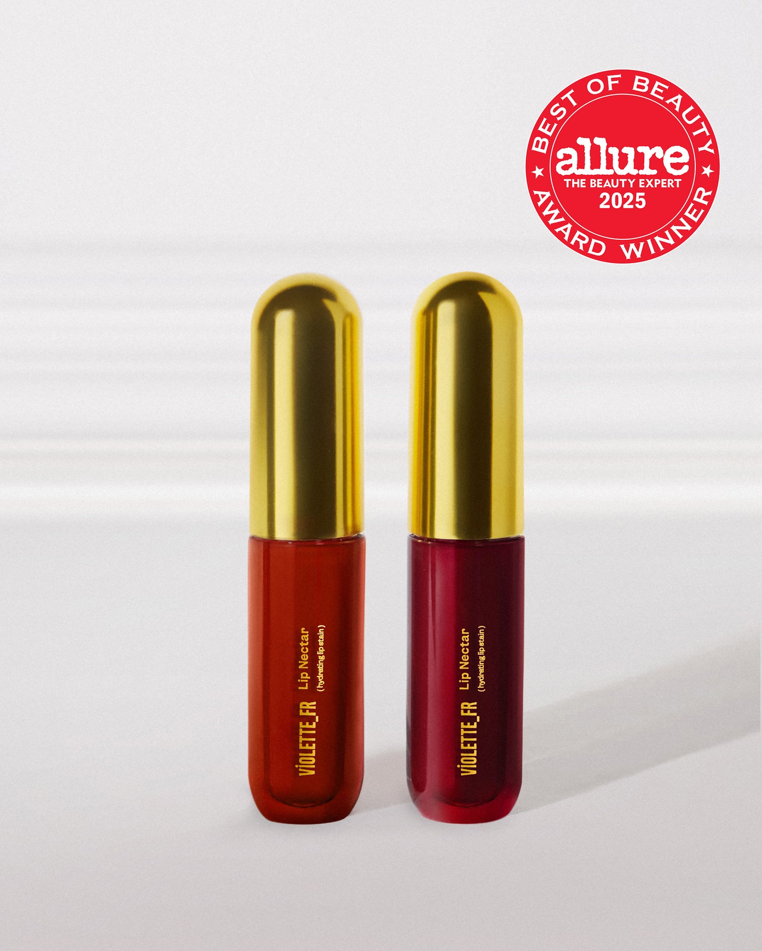 Two products, both 'VIOLETTE_FR Lip Nectar (hydrating lip stain)', one reddish-orange and one deep berry, with gold caps. An Allure Best of Beauty 2025 Award Winner badge is shown, reading 'BEST OF BEAUTY allure THE BEAUTY EXPERT 2025 AWARD WINNER'.