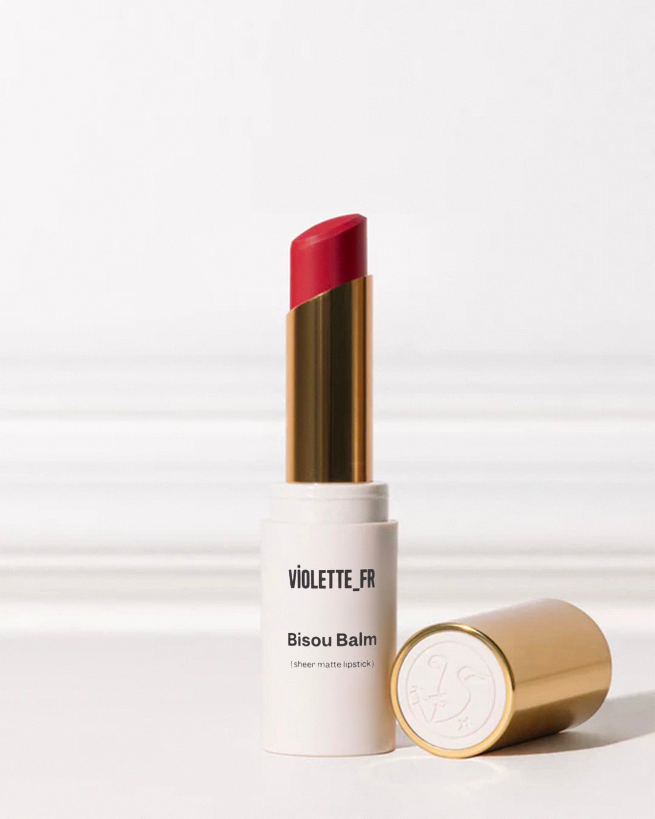 Bisou Balm - Bêtise - Bisou Balm (sheer matte lipstick) by VIOLETTE_FR: a matte off-white tube with a vibrant red bullet extended, next to its gold cap with an embossed logo. - Image 81 of 81