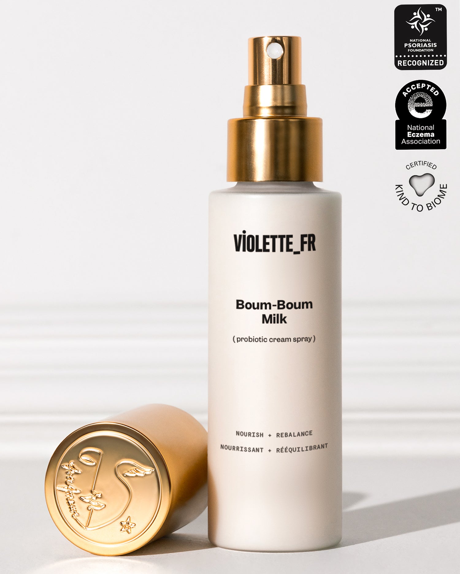 Violette_FR Boum-Boum Milk (3-in-1 cream spray) in a white bottle with a gold spray top and cap, recognized by the National Psoriasis Foundation, accepted by the National Eczema Association, and certified Kind to Biome.