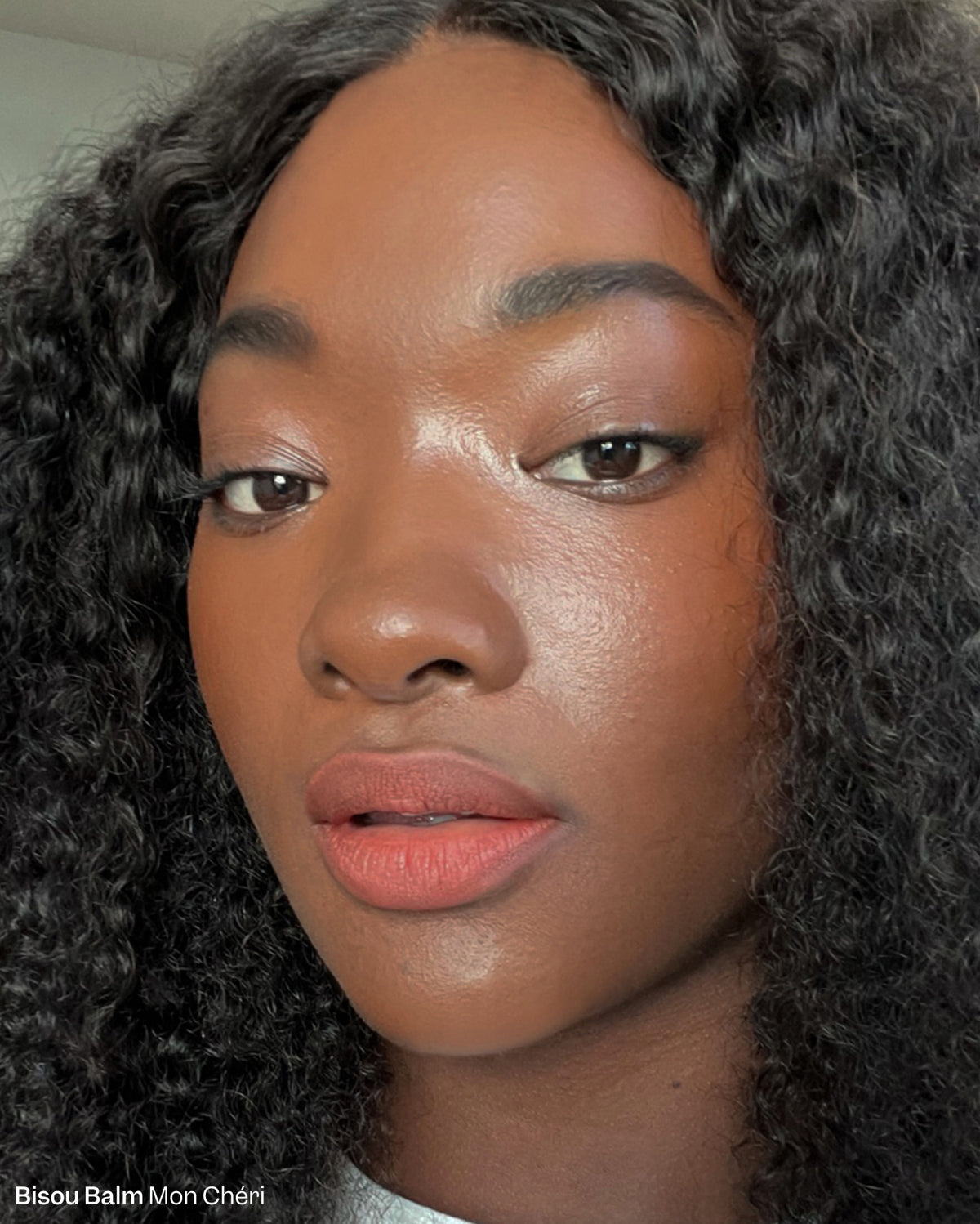 Bisou-Bisou Lip Duo - Mon Chéri. Close-up of a woman with deep skin tone wearing a warm terracotta lipstick shade. - Image 6 of 16