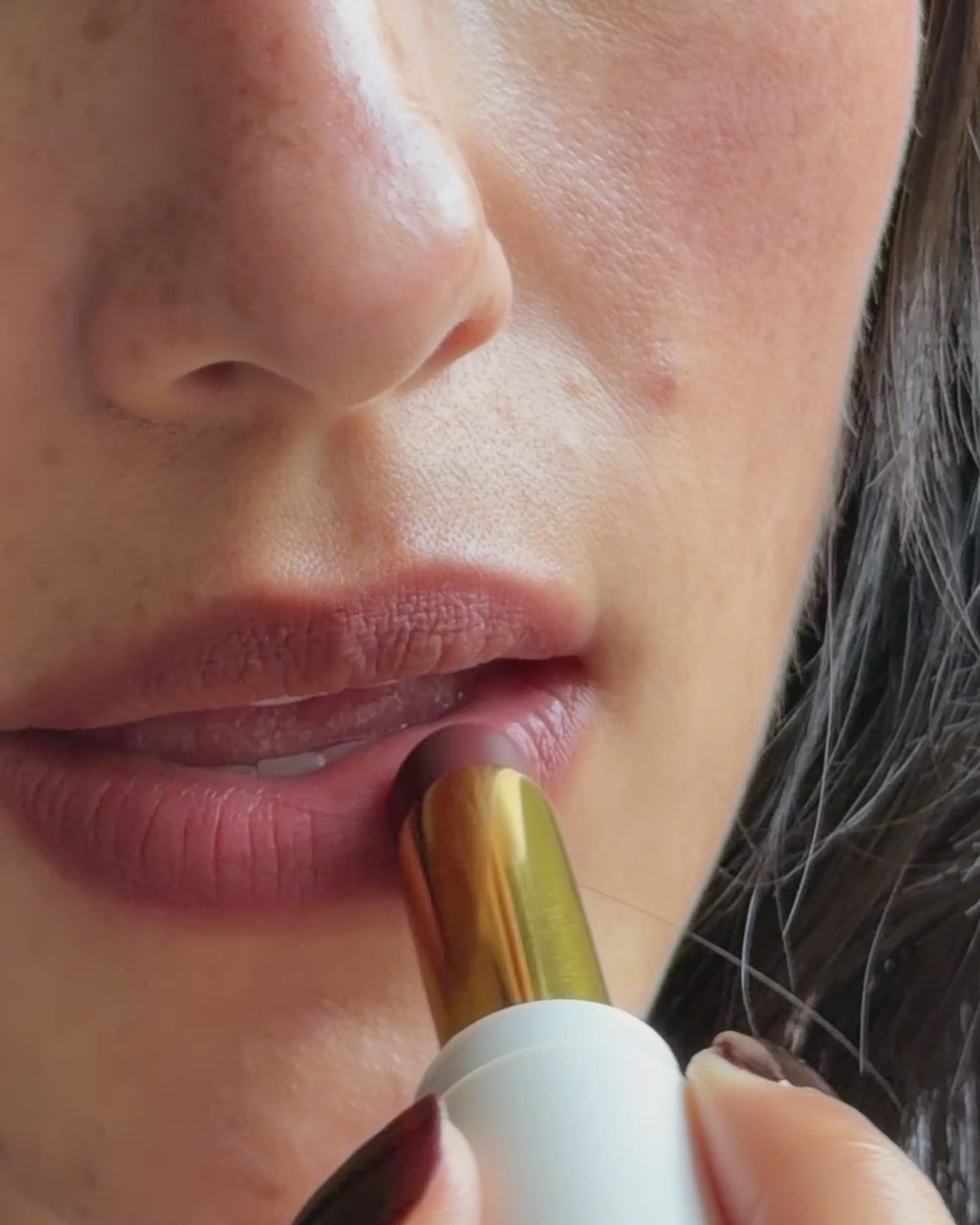 Bisou Balm - Calisson - Sheer matte balm swiped from the gold lipstick bullet across the lips, shown on medium skin tone.  - Image 25 of 25